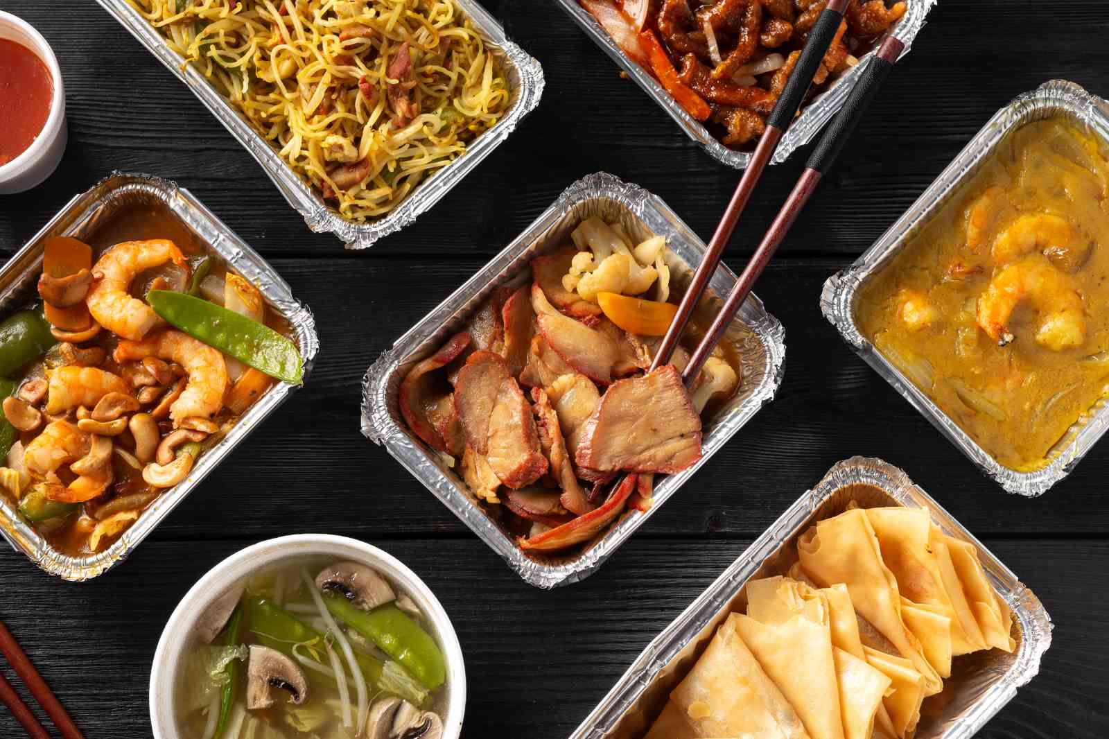 Selection of Jumbo takeaway dishes including king prawn curry, char siu, spring rolls, noodles and soup